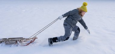 Karlı parkta çocuk oyunu. Çocuk düşen kar taneleriyle oynuyor. Kış eğlencesi Kışın çocuk portresi. Çocuk kahkahası ve hareket. Donmuş doğadaki duygusal anlar. Çocuk kış aktiviteleri. Kış eğlencesi