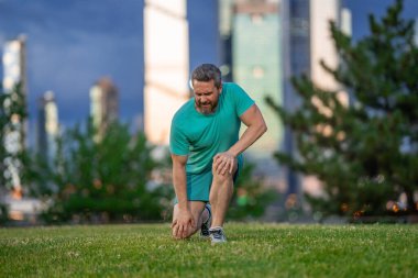 Antrenmandan sonra dizim kırıldı. Koşu sırasında bacağım ağrıyor. Dizini tutan yaralı bir adam. Koştuktan sonra bacakları ağrıyor. Dizinden yaralanan bir adam. Antrenman bacak ağrısı. Koşu diz travmasına yol açıyor. Bacak ağrısı.