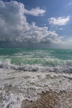 Turkuaz su dalgası hareketi. Yaz plajı. Sakin plaj. Lüks sahil beldesi. Parlak gökyüzü ve sahilde dalgalar. Güzel köpüklü kıyı şeridi. Deniz arka planı. Mavi okyanus. Kumsal