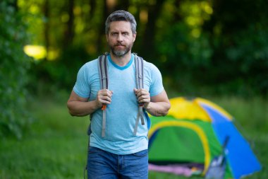 Adam ağaçların altında dinleniyor. Açık hava seyahati. Doğada kamp yapmak. Doğadaki özgürlük. Yaz kampı. Yürüyüş ve kamp macerası. Açık hava yaşam tarzı ve rahatlama. Ormanda bir tatil. Seyahatte dinleniyorum.