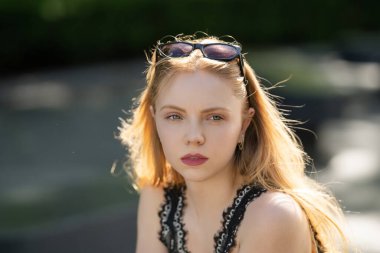 Güzel bir genç kadının yakın plan portresi. Kız dışarıda poz veriyor, yakın plan. Doğal güzellik portresi. Yumuşak doğal ciltli güzel bir yüz. Genç bir kadının yaz portresi. Zarif moda portresi