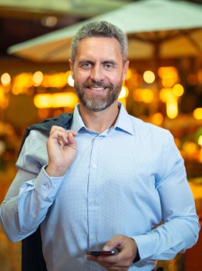 Gece lambasında telefonla konuşan bir iş adamı. İş adamı cep telefonu kullanıyor. Olgun iş adamı internette sohbet ediyor. İş adamı bir arama yapıyor. İş konuşmaları. İş adamı dışarıda telefonla konuşuyor.