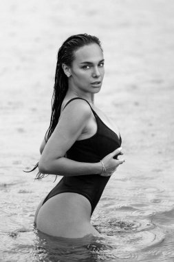 Yaz tatilinde doğa üzerine seksi bir model. Mayolu güzel bir kız suda seksi poz veriyor. Seksi yaz tatili. Egzotik ülke seyahati ve dinlenme konsepti. İnce vücut ve seksi vücut.