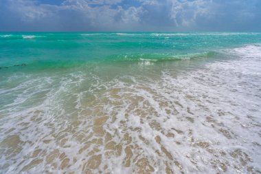 Turkuaz deniz dalgası hareketi. Yaz plajı. Sakin deniz. Lüks sahil beldesi. Parlak gökyüzü ve sahilde dalgalar. Güzel köpüklü kıyı şeridi. Deniz arka planı. Mavi okyanus. Kumsal. Deniz dalgaları