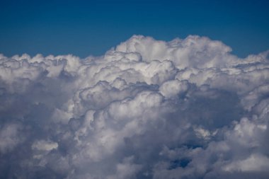 Kabarık bulutlu arka planlı mavi gökyüzü. Parlak mavi gökyüzü arkaplanı. Bulutlu beyaz bulutlar. Güneşli bir günde sakin bir gökyüzü. Bulutların arasından gün ışığı. Yumuşak bulutlu bahar gökyüzü