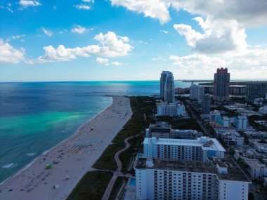 Miami 'de kumsalda güneşli yataklı, okyanus dalgalı bir plaj. Muhteşem manzaralı Miami Beach cenneti. Güney Sahili Miami cankurtaranı. Miami 'de huzurlu bir deniz kenarı inzivası. Kıyı gevşemesi