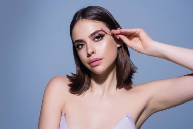 Beautiful woman with perfect shape eyebrows. Womans brows close up. Beautiful girl with eyebrow brush. Eyebrow correction. Long eyelashes and thick eyebrows