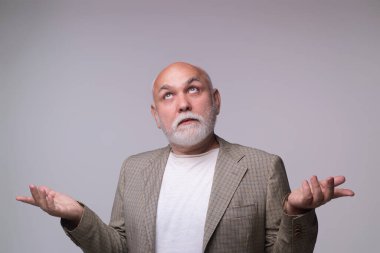 Şok olmuş yüzü olan kafası karışmış yaşlı bir adam. Kafası karışmış emekli adam. Yaşlı bir erkek, kafası karışmış birine duygusal tepki gösteriyor. Kafası karışmış olgun bir adamın portresi. Son sınıfın şok tepkisi.