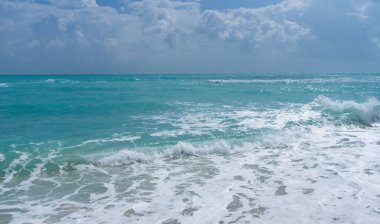 Deniz kıyısı. Renkli deniz kıyısı suyu. Sıcak okyanus esintisi. Yaz sahili. Deniz arka planı. Mavi okyanus. Kumsal. Okyanus dalgaları. Yaz mevsimi. Tropik sahil şeridi. Köpüklü dalga sıçraması