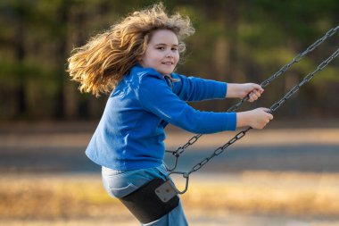 Salıncaktaki çocuk. Çocuk bahçesinde mutlu bir çocuk. Kaygısız çocuk dışarıda sallanıyor. Mutlu çocuklar dışarıda oynuyor. Sarışın çocuk mutluluktan uçuyor. Dışarıdaki oyuncu çocuk. Çocuk suratı. Mutlulukla sallanan çocuk