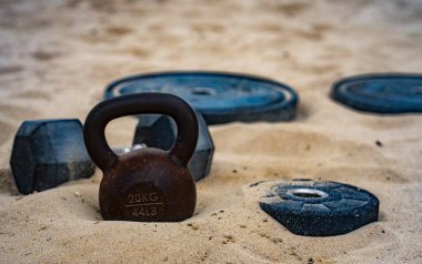 Çaydanlık çanı eğitimi. Kumda spor dambılları. Sportif açık hava sporu. Spor ağırlık kaldırma egzersizi. Halter kaldırma. Spor motivasyon egzersizi.