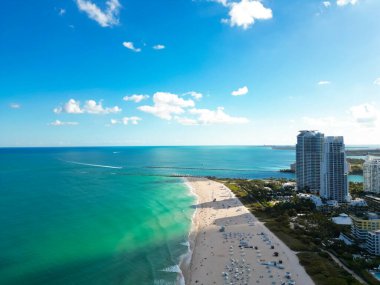 Mavi gökyüzünde bulutlu Miami şehri manzarası. Miami 'nin güney sahili. Miami 'deki gökdelenler, hava manzarası. Güney sahili. Miami Sahil İskelesi. Miamis kıyıları