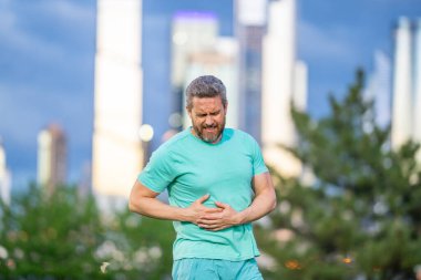 Egzersiz sırasında göğüs ağrısı çeken bir adam. Koşucu kalp krizi belirtileri gösteriyor. Dışarıda kalp krizi geçiren yakışıklı bir erkek. Kardiyo kalp krizi geçirdi. Acı dolu bir kalp enfarktüsü anı.