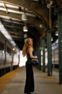 Tren yolculuğu. Seyahat için bekleyen bir kadın. Genç gezgin. Tatil gezisinde modellik yap. Güzel bir gezginin portresi. Tren istasyonundaki kadın. Yaz tatili seyahati. Seyahat ve stil