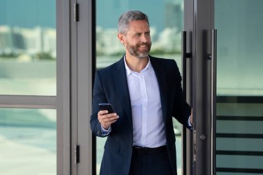 İş adamı bir ofis binasına giriyor. Yetişkin bir iş adamı toplantıya giriyor. İş adamı ofis kapısından içeri giriyor. Karizmatik iş adamı kapıdan giriyor. İş anlaşması