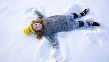 Karlı kış parkındaki çocuk. Kış çocuğu kar taneleriyle oynar. Çocuklar kış tatili. Kışın çocukluk anıları. Kışın bir çocuğun portresi. Noel tatilinde dondurulmuş eğlence