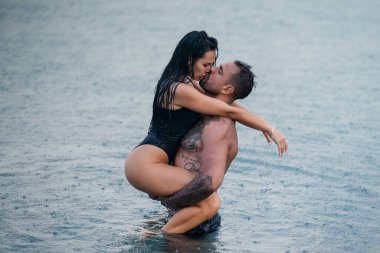 Suyun içindeki seksi modeller. Sevgi dolu bir çift. Birbirine aşık yaz çifti. Şehvetli bir çift yazın denizde tatil yapıyor. Tutkulu çift deniz suyunda öpüşüyor ve sarılıyor. Yaz aşıkları