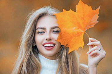 Mutlu genç bayanın güz yüzü. Sonbahar güz döneminde gülümseyen kız. Düşen yaprakları olan güzel kız. Sonbahar modeli ve sonbahar yaprağı. Mutlu kızın sonbahar portresi