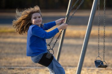 Çocuk salıncakta eğleniyor. Çocuk bahçesinde mutlu bir çocuk. Kaygısız çocuk dışarıda sallanıyor. Mutlu çocuklar dışarıda oynuyor. Sarışın çocuk heyecandan titriyor. Dışarıdaki oyuncu çocuk. Eğlenceli çocuk suratı