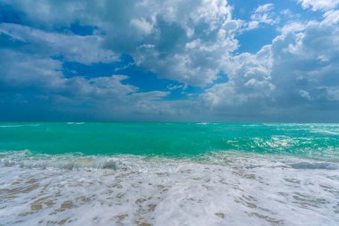 Turkuaz deniz dalgası hareketi. Yaz plajı. Sakin deniz. Lüks sahil beldesi. Parlak gökyüzü ve sahilde dalgalar. Güzel köpüklü kıyı şeridi. Deniz arka planı. Mavi okyanus. Kumsal. Deniz dalgaları