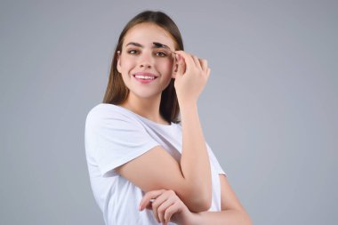 Koyu kaşlı güzel bir kadın kaş fırçası tutuyor. Kaş kaplaması. Güzellik prosedürlerini uygula. Kaş ve kaş çizgisi, kaş çizgisi.