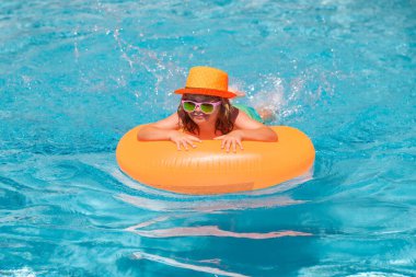 Havuzdaki çocuk. Çocuklar yaz tatili konsepti. Yaz çocukları sahilde deniz suyunda portre yapar. Çocuk havuzda su sıçratıyor, eğleniyor, boş vakit geçiriyor.