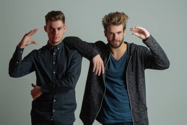 Stüdyoda poz veren iki erkek model. Moda tarzı gösteren seksi eşcinsel çift. Tarz sahibi erkekler gurur duyar. Zarif kıyafetli yakışıklı erkek arkadaş. Moda erkek modeller. Moda adamları poz veriyor. Şık eşcinsel çift.