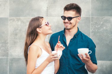 Birlikte kahve içen genç bir çift. Kafenin dışında romantik bir randevu. Kadın ve erkek aynı bardağı paylaşıyor. Mutlu sevgili gülümsemesi. Ilık içkinin tadını çıkaran iki arkadaş. Aşk ve yaşam tarzı çifti