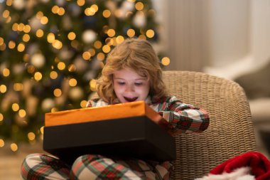 Mutlu noeller. Neşeli şirin çocuk hediyeleri açıyor. Sabahları ağaçların yanındaki çocuklar. Noel hediyeleri odada. Sürpriz çocuk Noel hediyelerini açıyor.