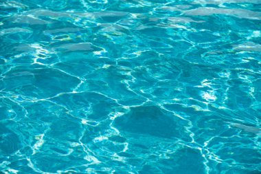 Yüzme havuzunda güneş yansımalı dalgalı su. Dalgalı su arkaplanı