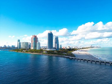 Mavi gökyüzünde bulutlu Miami şehri manzarası. Miami 'nin güney sahili. Miami 'deki gökdelenler, hava manzarası. Güney sahili. Miami Sahil İskelesi. Miamis kıyıları