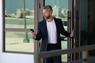 İş adamı bir ofis binasına giriyor. Yetişkin bir iş adamı toplantıya giriyor. Ofis kapısından giren bir iş adamı. Karizmatik iş adamı kapıdan giriyor. İş anlaşması