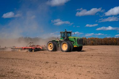Traktör toprağa toprak sürüyor. Toprak üzerinde çiftçilik. Kırsal tarım arazilerinde traktör. Toprakta çalışan tarım makinesi ya da traktör. Çekici tarla sürme çiftliği. Çiftlik arazisi