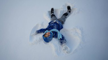 Kar meleği yapan bir çocuk. Karda yatan mutlu çocuk. Kardaki melek çocuk. Karlı melek kanatlı kış çocukları. Karlı bir günde gülümseyen bir çocuk. Kar Gölü Meleği 'ndeki kaygısız çocuk. Noel neşesi