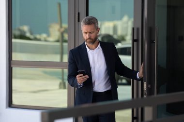 İş adamı bir ofis binasına giriyor. Yetişkin bir iş adamı toplantıya giriyor. Ofis kapısından giren bir iş adamı. Karizmatik iş adamı kapıdan giriyor. İş anlaşması