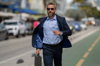 Toplantıya koşan zengin bir işadamı. İşadamı yolda koşar. Takım elbiseli bir iş adamı işe koşuyor. İş adamı atlayıp dışarı koşar. İş adamı buluşmak için koşuyor. İşadamı acele et.