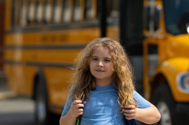 Okula dönelim. Genç öğrenciler için okul başlıyor. Okul otobüsünün yanında sırt çantalı bir çocuk. Çocuk okula gidiyor. Çocuk derse gidiyor. Okul çocuğu.