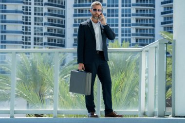 Dışarıdaki telefondan iş adamı aradı. Kendine güvenen bir adam arama yapıyor. Takım elbiseli bir yönetici arıyor. Ciddi bir iş adamı stratejiyi tartışıyor. İş adamı cep telefonundan arıyor. İş çağrıları