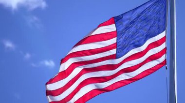 Mavi gökyüzünde dalgalanan Amerikan bayrağı. Birleşik Devletler bayrağı. Rüzgarda bayrak. Amerika 'nın vatansever bayrakları. ABD ulusal sembolü. Özgürlük ve demokrasi. Bağımsızlık Günü. Yıldızlar ve çizgiler. ABD bayrağı sallıyor