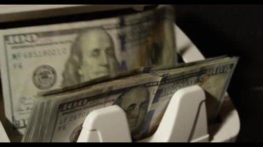 Nakit sayıyorum. Dolar senetleri hareketi. Para makinesi dolar sayıyor. Kağıt para. 100 dolarlık banknotları sayıyorum. Kolay para. Dolar banknotlu sayma makinesi. Para sayacı. Bankacılık kavramı