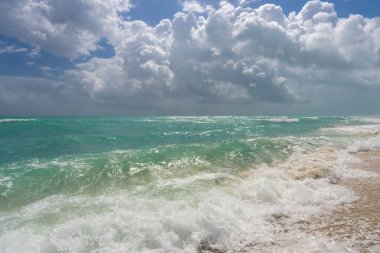 Turkuaz deniz dalgası hareketi. Yaz plajı. Sakin deniz. Deniz kıyısındaki tatil. Parlak gökyüzü ve sahilde dalgalar. Güzel köpüklü kıyı şeridi. Deniz arka planı. Mavi okyanus. Kumlu okyanus plajı. Deniz dalgaları