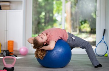 Kid practicing sport at home. Cute little boy doing morning fitness. Young sporty kid sport exercising in room. Child sport. Kids sport concept. Kid enjoying fitness training indoors