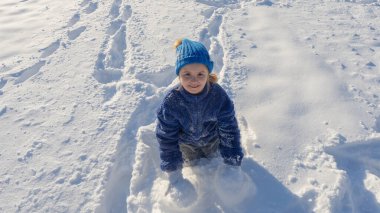 Çocuk karla oynuyor. Kış çocuğu kar taneleriyle oynar. Çocuklar kış tatili. Kış çocukları portresi. Kışın çocukluk anıları. Kışın bir çocuğun portresi. Kar eğlencesi