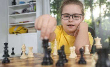 Evde satranç oynayan bir çocuk. Çocuk satranç tahtasında strateji çalışıyor. Tatlı çocuk düşünceli bir satranç oynuyor. Okul çocuğu satranç figürlerine odaklanıyor. Gençler mantığı satrançla öğreniyor