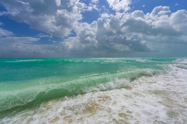 Turkuaz su dalgası hareketi. Yaz plajı. Sakin plaj. Lüks sahil beldesi. Parlak gökyüzü ve sahilde dalgalar. Güzel köpüklü kıyı şeridi. Deniz arka planı. Mavi okyanus. Kumsal