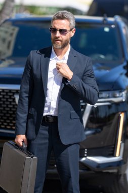 Lüks bir arabanın yanında zengin bir işadamı. Zengin bir iş adamı. Zarif zengin iş adamı. Pahalı arabası olan bir patron. Premium arabada duran zengin bir işadamı. İş başarısı. Zenginlik kavramı