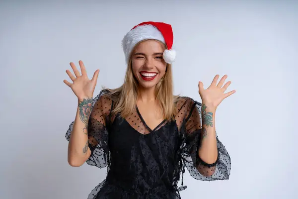 Vor Weißem Hintergrund Verströmt Eine Junge Frau Mit Weihnachtsmütze Und Stockbild