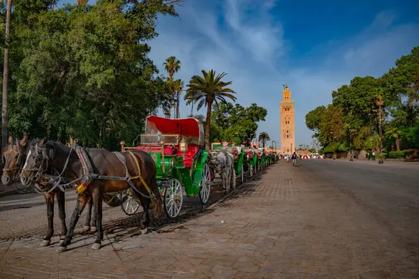 Al Koutoubia Minaret, Marakeş Fas 'ta yol boyunca at arabalarıyla Jamae El Fna' dan izlendi.