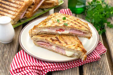 Jambonlu, peynirli ve domatesli ızgara tam buğday ekmekli sandviç.