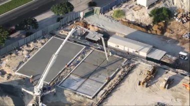 DUBAI, BAE - CIRCA 2022: İnşaat alanındaki çelik takviyesine sıvı beton veya çimento döken işçilerle güçlendirilmiş beton plakaya beton döken beton karıştırıcı mekanizması.